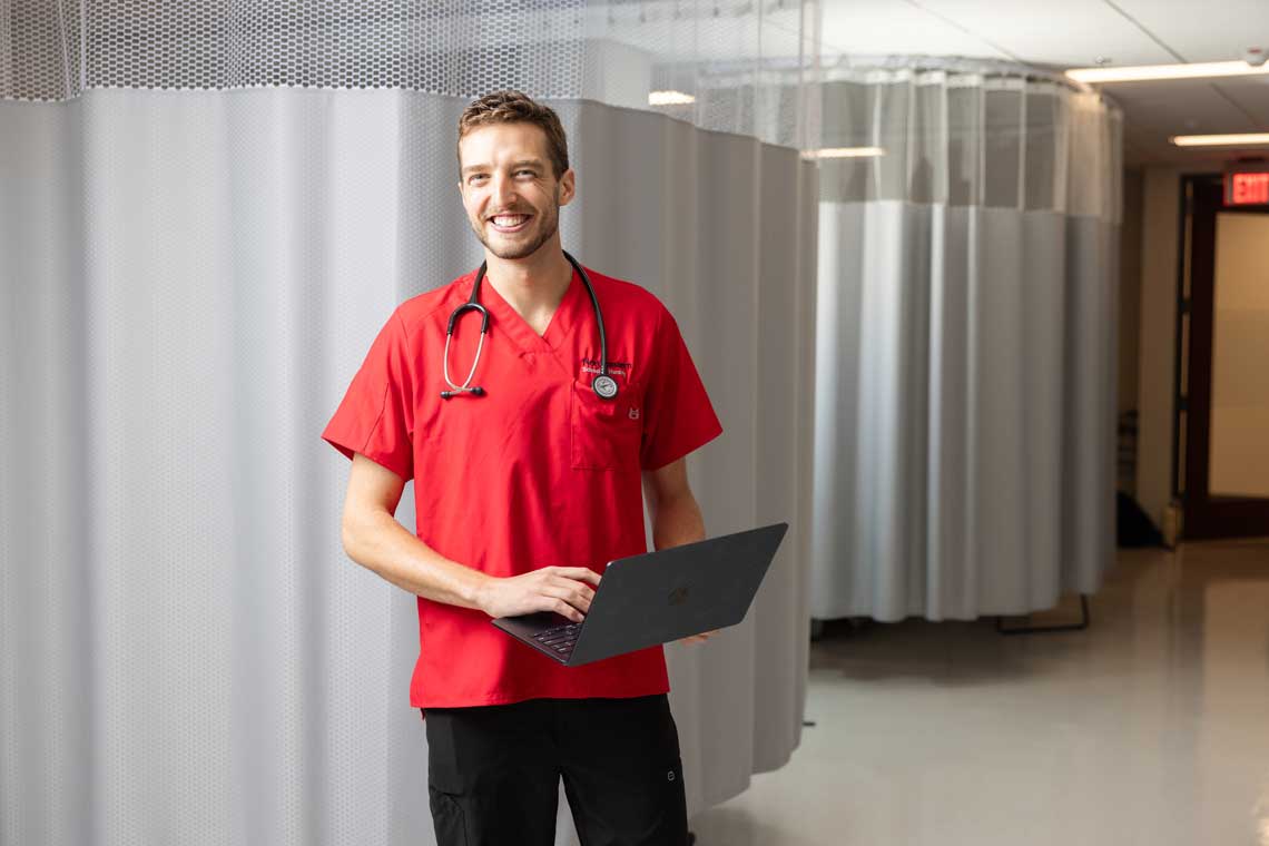 nursing student standing in sim lab