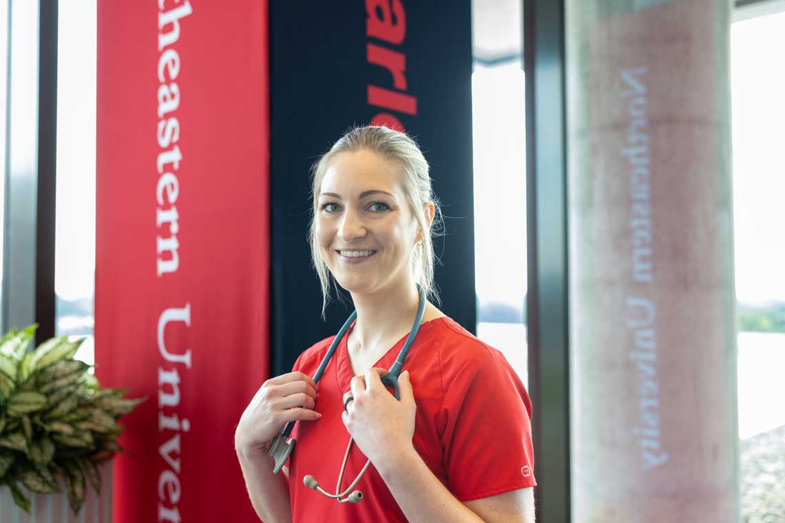 NEU nursing student standing in lobby smiling