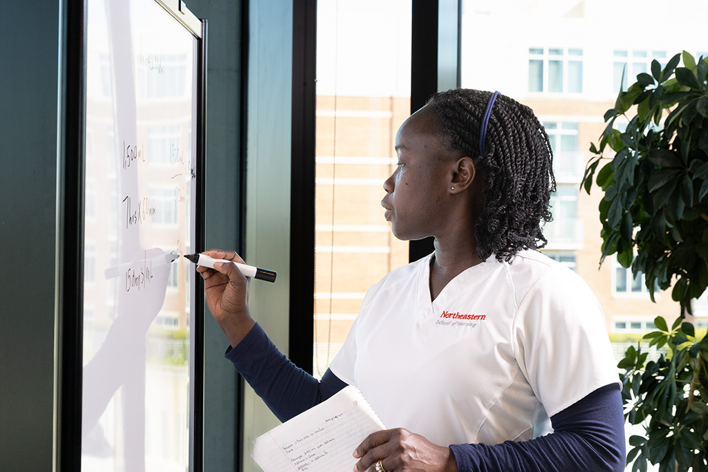 nursing student writing on whiteboard