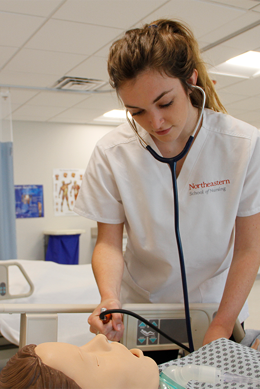 Northeastern ABSN student working with sim manikin