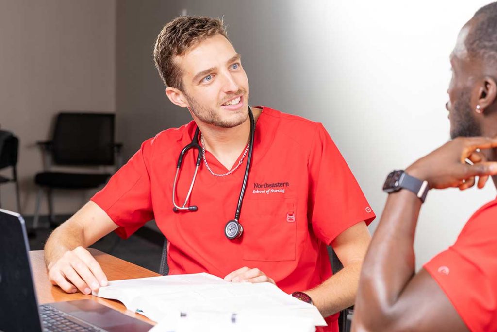 two NEU nursing students studying and talking