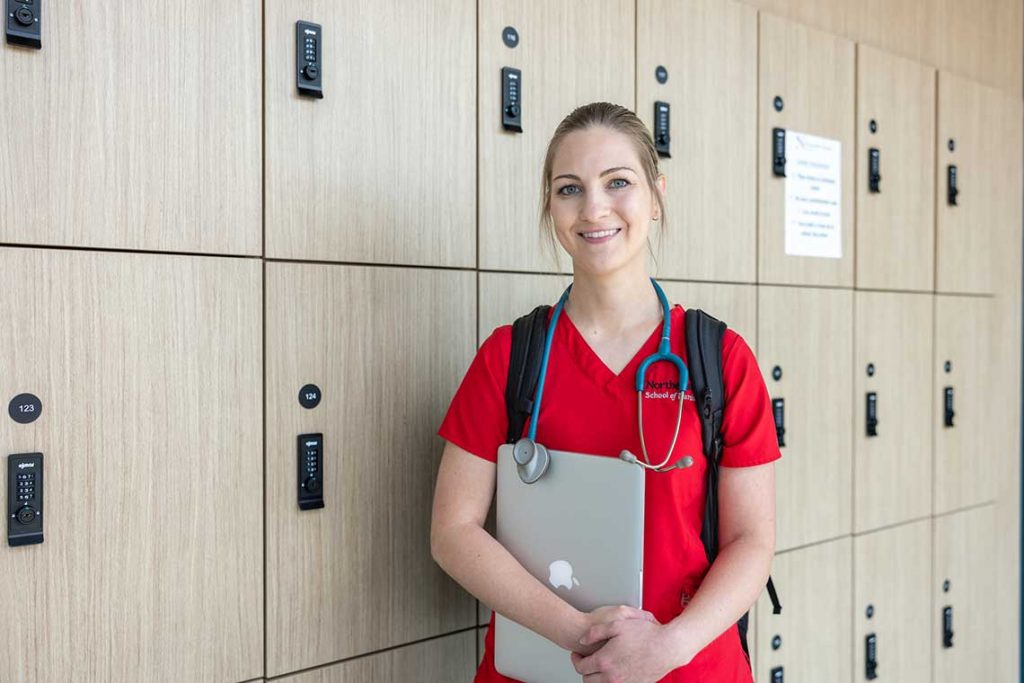 NEU nursing student standing by lockers