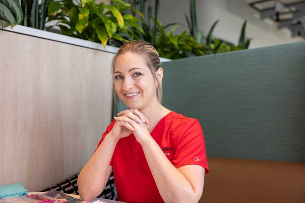 NEU nursing student sitting at desk smiling