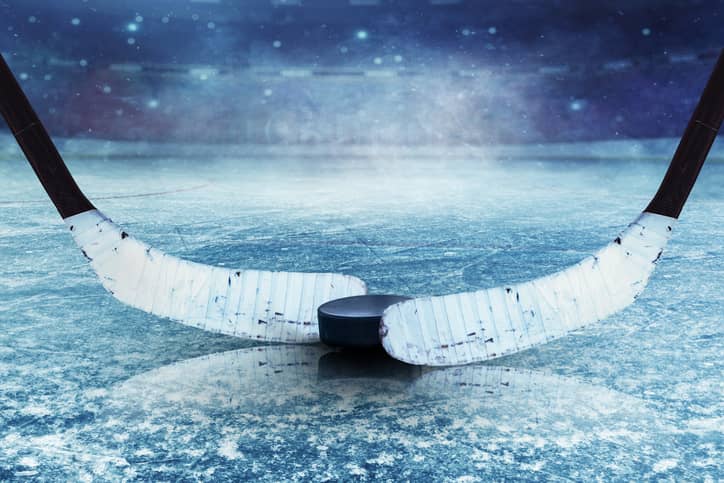 two hockey sticks with puck