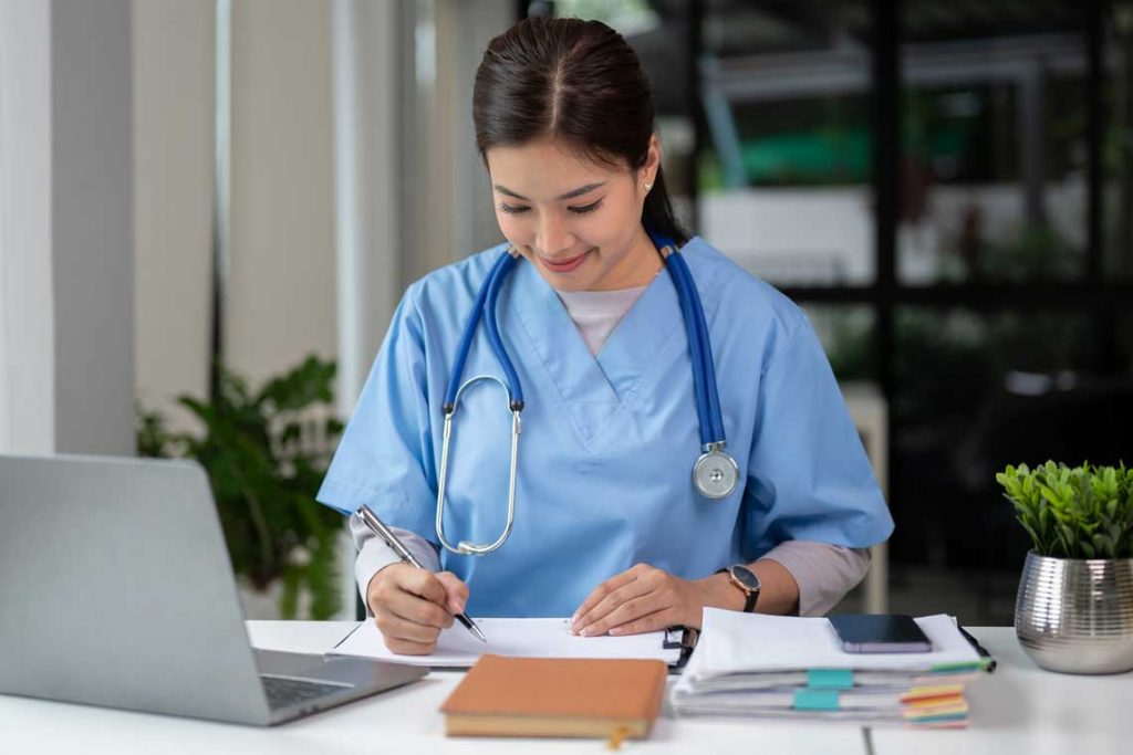 nurse writing at desk