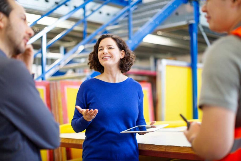 three people talking in warehouse