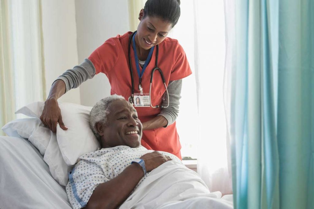 nurse helping adjust patient pillow